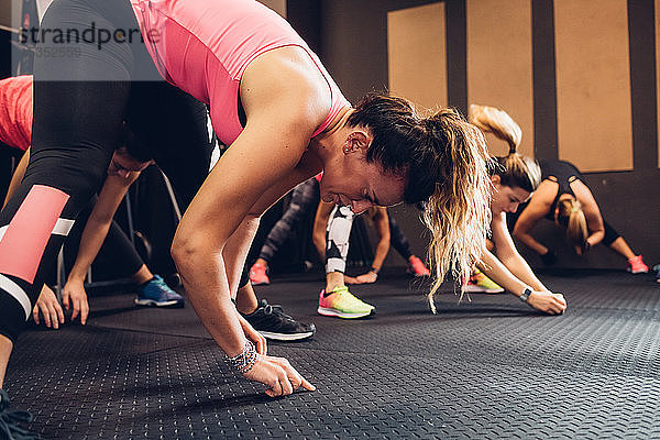 Frauen trainieren im Fitnessstudio  Bodenberührung  Seitenansicht