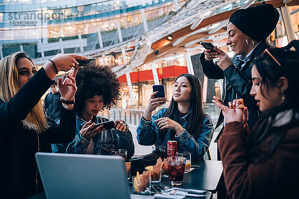 Freunde fotografieren ihr Essen und ihre Getränke im Freiluftcafé  Mailand  Italien