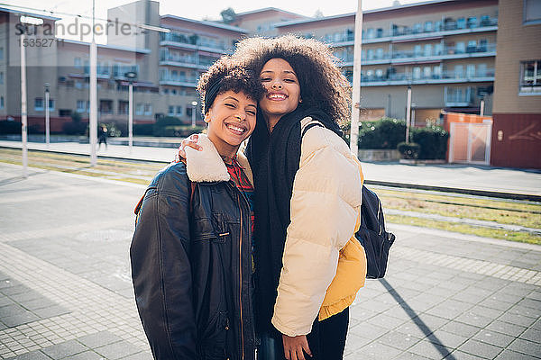 Zwei junge Frauen posieren auf dem städtischen Bürgersteig  Porträt