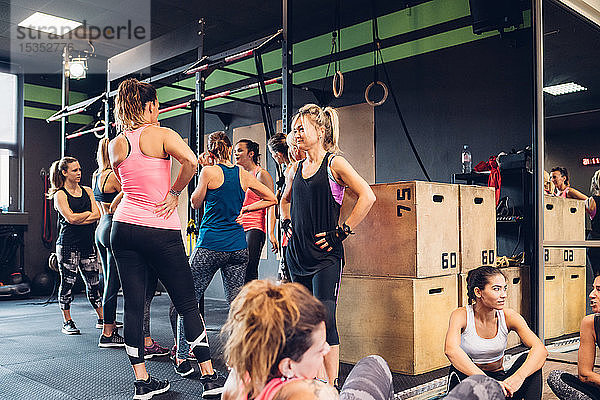 Gruppe von Frauen trainiert im Fitnessstudio  macht eine Pause und plaudert