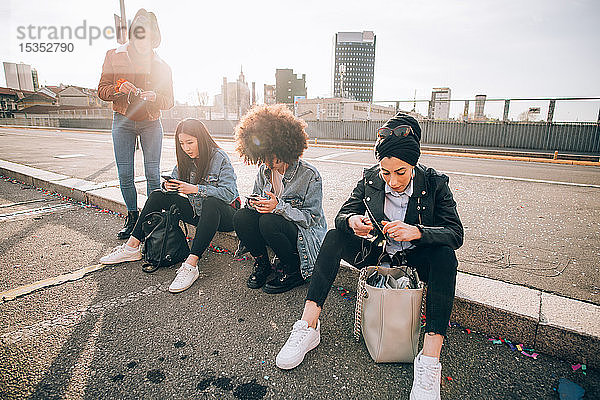 Freunde sitzen am Bordstein und schreiben Texte  Mailand  Italien