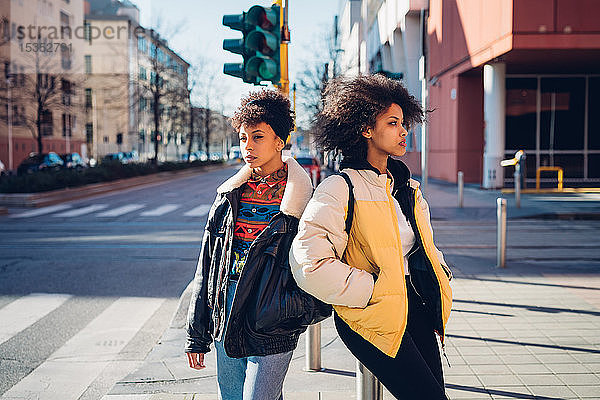 Zwei coole junge Frauen stehen auf der Straße in der Stadt