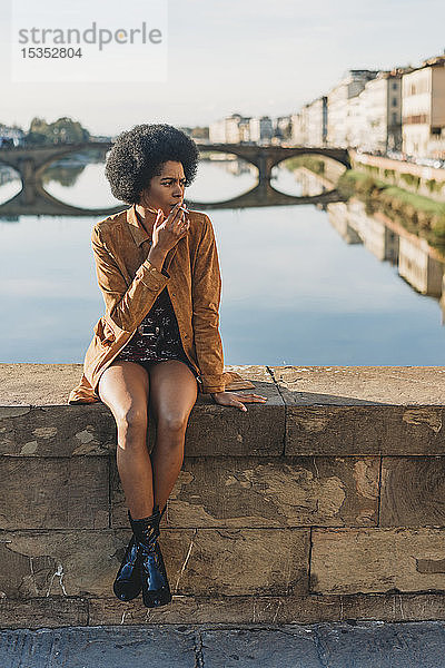 Junge Frau mit Afrohaaren raucht auf der Brücke  Florenz  Toskana  Italien