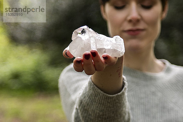 Frau hält Heilkristall für Reiki