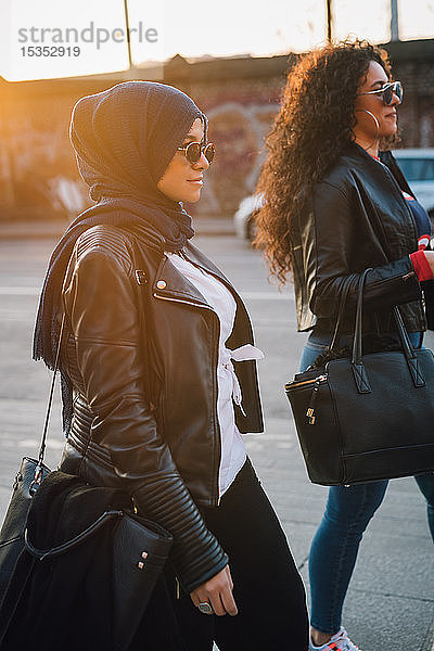 Junge Frau im Hidschab und beste Freundin beim Stadtbummel