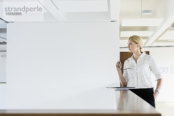 Geschäftsfrau macht Pause im Bürokorridor