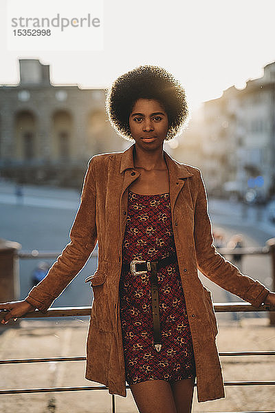 Junge Frau mit afrofarbenen Haaren  die am Geländer lehnt  Florenz  Toskana  Italien