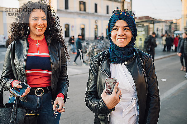 Junge Frau im Hidschab mit bestem Freund auf der Straße der Stadt