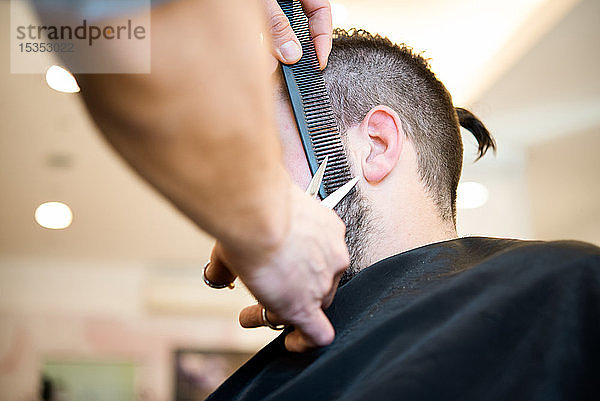 Friseur schneidet Kunden beim Friseur den Bart