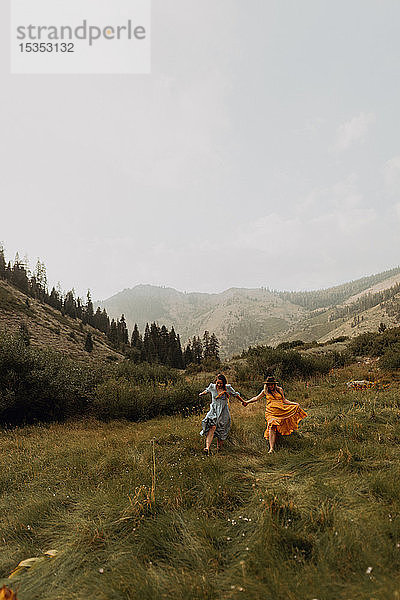 Zwei Frauen halten Händchen und laufen im ländlichen Tal  Mineral King  Kalifornien  USA