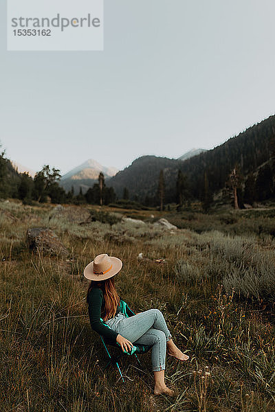 Junge Frau in Stetson entspannt auf Liegestuhl im ländlichen Tal  Mineral King  Kalifornien  USA