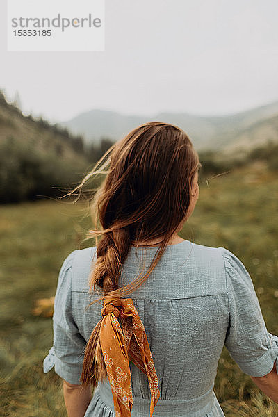 Junge Frau mit geflochtenem Haar schaut auf ein ländliches Tal  Rückansicht  Mineral King  Kalifornien  USA