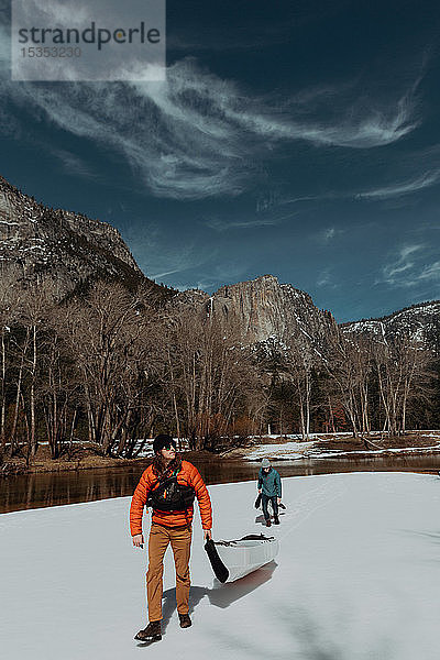 Freunde schleppen Kajak über den Schnee  Yosemite Village  Kalifornien  Vereinigte Staaten