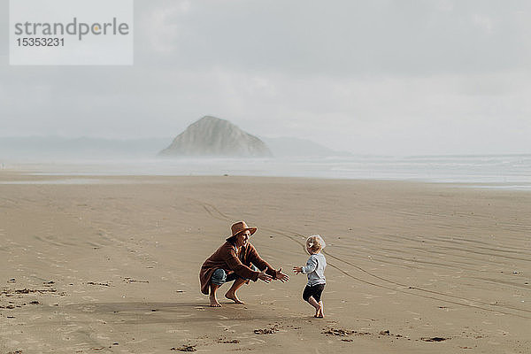 Mutter und Kleinkind spielen mit Sand am Strand  Morro Bay  Kalifornien  Vereinigte Staaten
