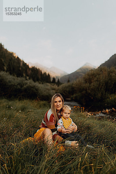 Weibliches Kleinkind sitzt auf dem Schoss der Mutter am ländlichen Fluss  Porträt  Mineral King  Kalifornien  USA