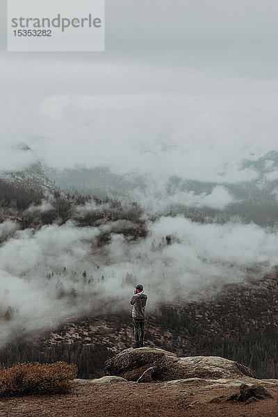 Wanderer genießt Aussicht auf nebeldurchzogenes Tal  Yosemite National Park  Kalifornien  Vereinigte Staaten