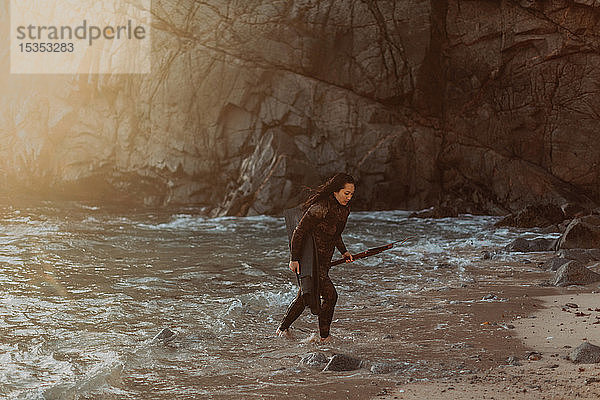 Frau mit Schwimmflossen und Harpune am Strand  Big Sur  Kalifornien  Vereinigte Staaten