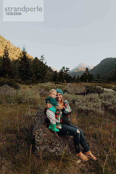 Mutter und Kleinkind auf einem Felsblock im ländlichen Tal sitzend  Porträt  Mineral King  Kalifornien  USA