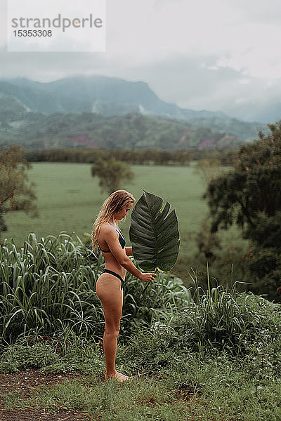 Frau im Bikini mit großem Blatt in der Hand  Princeville  Hawaii  US