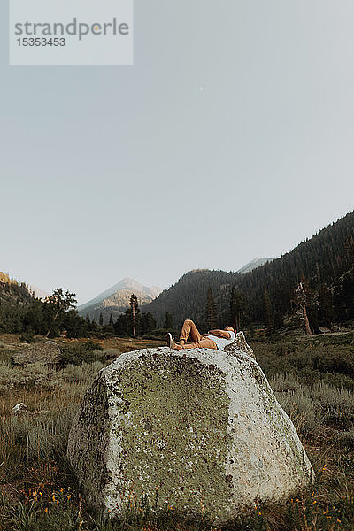 Auf einem Felsblock liegender junger Mann im ländlichen Tal  Mineral King  Kalifornien  USA
