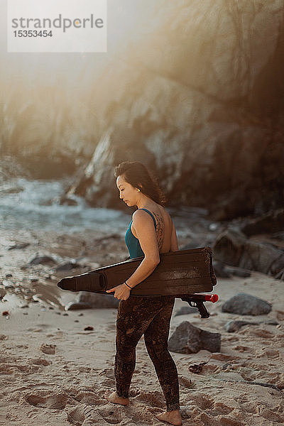 Frau mit Schwimmflossen und Harpune am Strand  Big Sur  Kalifornien  Vereinigte Staaten