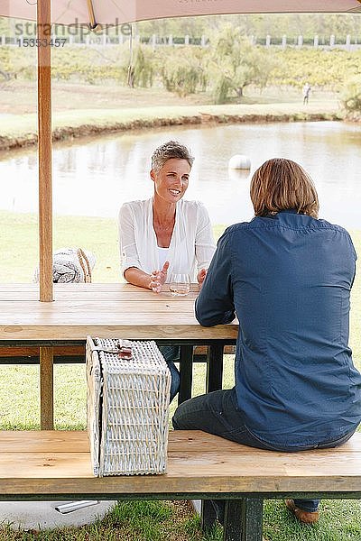 Paar mit Picknickkorb beim Entspannen am Teich  Kapstadt  Südafrika