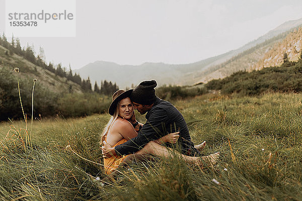 Mittelgroßes erwachsenes Paar im ländlichen Tal sitzend und umarmend  Porträt  Mineral King  Kalifornien  USA