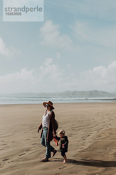 Mutter und Kleinkind gehen am Strand spazieren  Morro Bay  Kalifornien  Vereinigte Staaten
