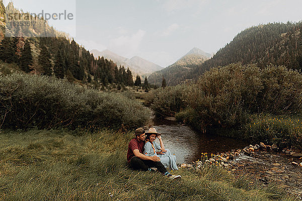 Junges Paar sitzt am ländlichen Fluss  Mineral King  Kalifornien  USA