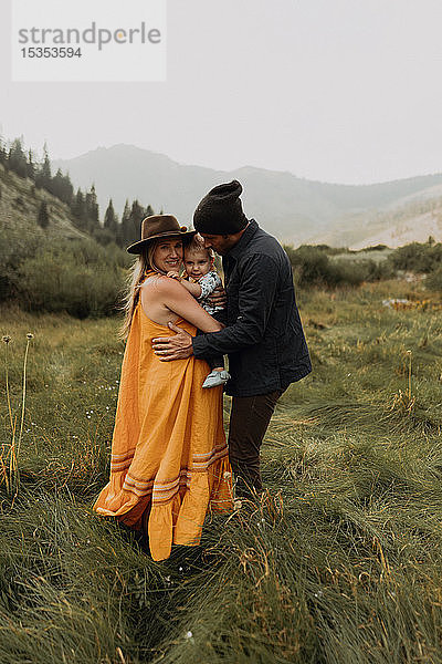 Schwangeres Paar mittlerer Erwachsener umarmt Kleinkind-Tochter in ländlichem Tal  Porträt  Mineral King  Kalifornien  USA