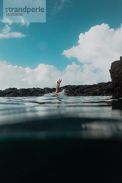 Schwimmer taucht von Felsen ins Meer  Princeville  Hawaii  USA