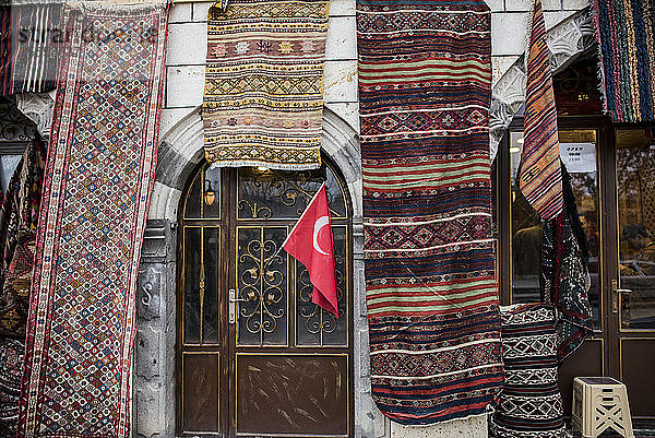 Ausstellung einer Vielzahl von Teppichen und Läufern an der Fassade eines Geschäfts  Goreme  Kappadokien  Türkei