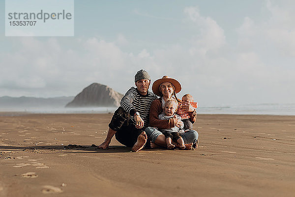 Eltern und Kinder am Strand sitzend  Morro Bay  Kalifornien  Vereinigte Staaten