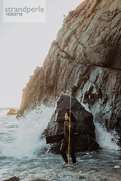 Frau mit Schwimmflossen und Speer am Strand  Big Sur  Kalifornien  Vereinigte Staaten