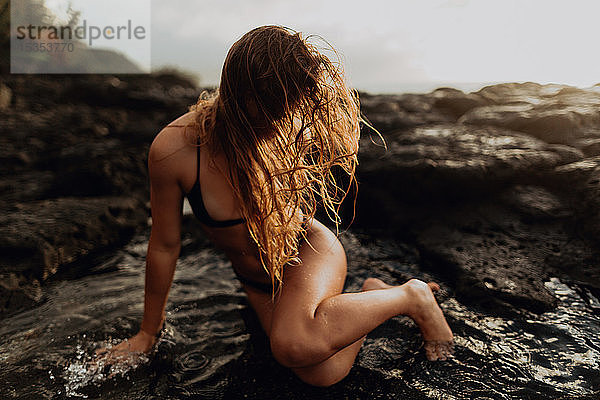 Frau posiert auf Felsen am Meer  Princeville  Hawaii  USA