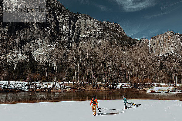 Freunde schleppen Kajak über den Schnee  Yosemite Village  Kalifornien  Vereinigte Staaten