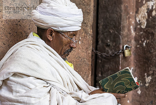 Äthiopisch-orthodoxer Priester beim Bibellesen in der Nordgruppe der Felsenkirchen; Lalibela  Region Amhara  Äthiopien