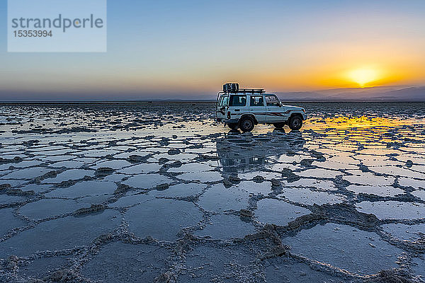 Fahrzeug mit Allradantrieb auf den Salzebenen des Karum-Sees (Assale-See) bei Sonnenuntergang  Danakil-Senke; Afar-Region  Äthiopien