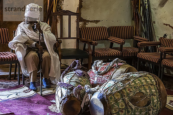 Äthiopisch-orthodoxer Priester und Gebetstrommeln in der in den Fels gehauenen Kirche von Abreha we Atsbeha; Region Tigray  Äthiopien