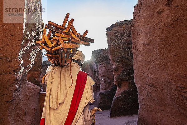 Äthiopisch-orthodoxer Priester mit Gebetsstäben bei Biete Qeddus Mercoreus (Haus des Heiligen Mercurius oder Haus des Evangelisten Markus) Äthiopisch-orthodoxe Felsenkirche in der Südgruppe der Felsenkirchen; Lalibela  Region Amhara  Äthiopien