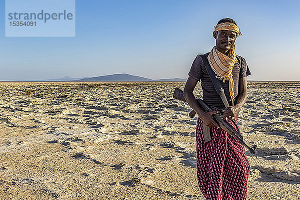 Afar-Mann mit einem Gewehr in den Salinen des Karum-Sees (Assale-See)  Danakil-Senke; Afar-Region  Äthiopien