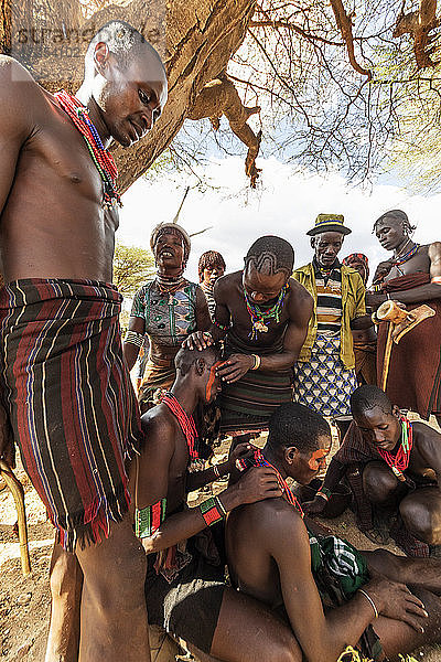 Hamer-Männer  die sich vor einer Stiersprung-Zeremonie  mit der ein Junge in die Männlichkeit eingeführt wird  im Dorf Asile im Omo-Tal  Äthiopien  das Gesicht bemalen