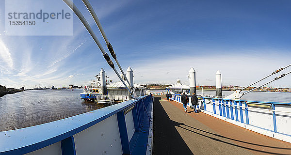 Menschen gehen den Pier hinunter in Richtung einer Fähre auf dem Fluss Tyne; South Shields  Tyne and Wear  England