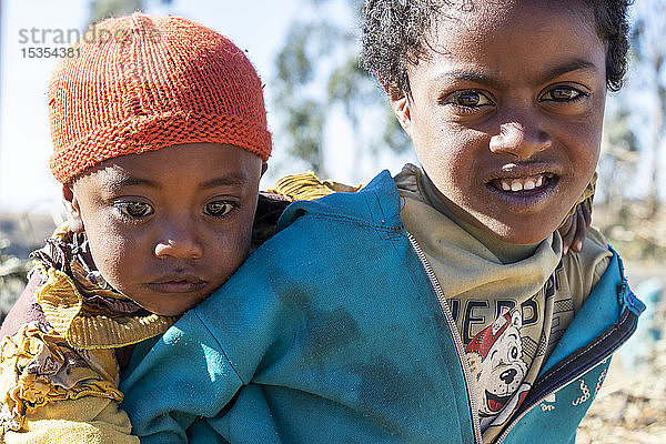 Äthiopisches Mädchen  das einen kleinen Jungen trägt  Simien-Gebirge; Region Amhara  Äthiopien