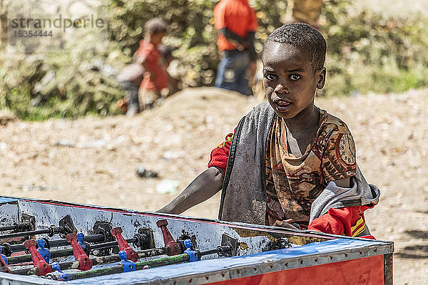 Äthiopischer Junge spielt Tischfußball  Koka-Stausee (Gelila-See); Region Oromia  Äthiopien