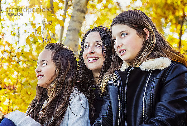 Eine Mutter und ihre beiden Töchter genießen an einem warmen Herbstnachmittag in einem Stadtpark die Schönheit der Natur: Edmonton  Alberat  Kanada