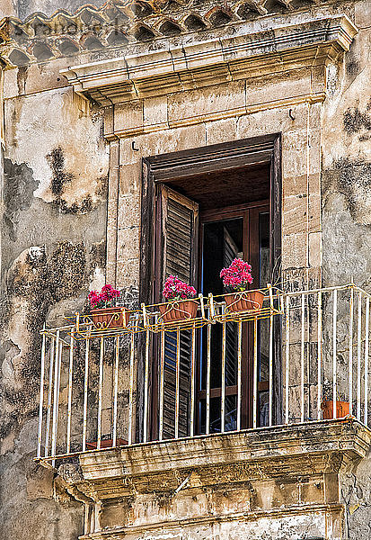 Fassade eines Wohnhauses mit Balkon und blühenden Pflanzen; Syrakus  Sizilien  Ortigia  Italien