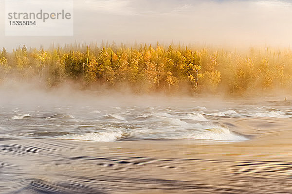 Fließendes Wasser mit Nebel über einem Fluss und herbstlich gefärbtem Wald  Sturgeon Falls  Whiteshell Provincial Park; Manitoba  Kanada