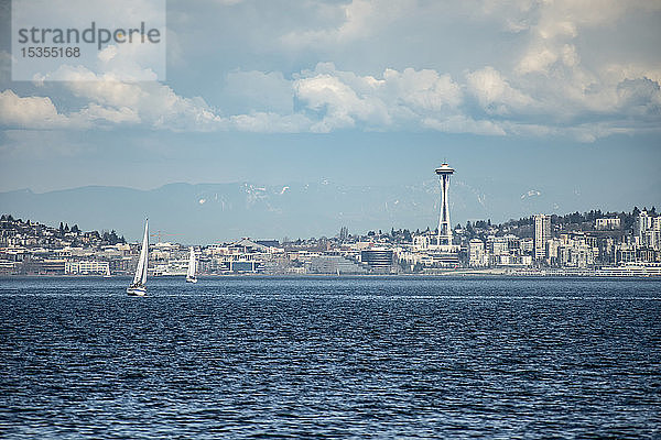 Die Stadt Seattle und die ikonische Space Needle  während Segelboote die Elliott Bay durchqueren. Ein warmer Frühlingstag erzeugt Hitzewellen  die aus dem Wasser aufsteigen; Seattle  Washington  Vereinigte Staaten von Amerika