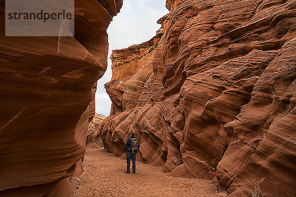 Mann  der im Slot Canyon  bekannt als Owl Canyon  in der Nähe von Page spazieren geht; Arizona  Vereinigte Staaten von Amerika